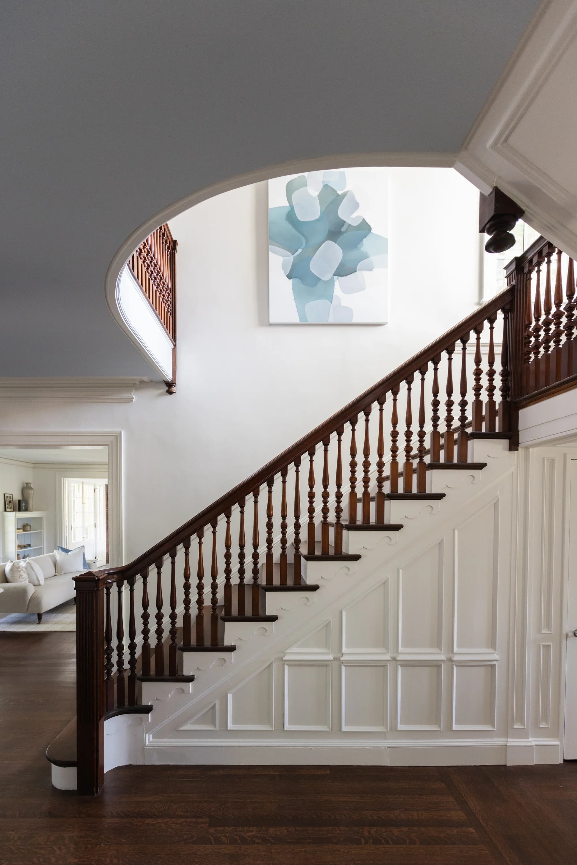 Restored dark wood staircase with white paneling and abstract artwork at Project Two Ninety in Providence, Rhode Island