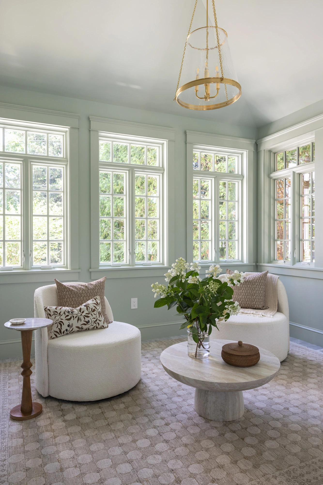 Furnished sunroom seating with boucle chairs and marble table at Project Three Ten in Providence, Rhode Island