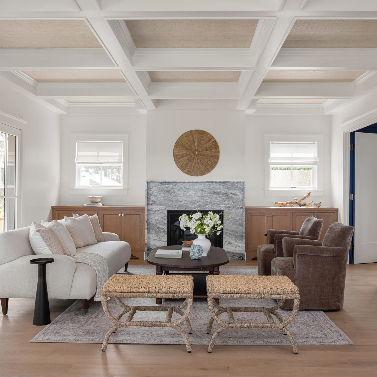 Living room with coffered ceiling, marble fireplace and woven wall art at Project Three Ten on Blackstone Boulevard in Providence, Rhode Island