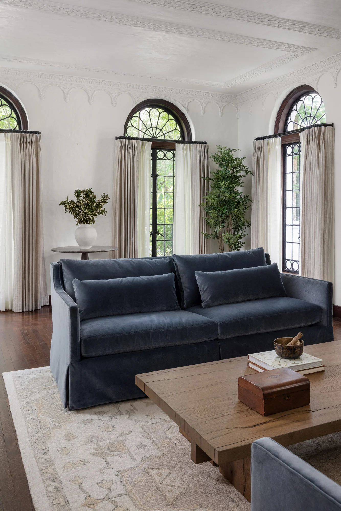 Blue velvet sofa facing arched windows in the living room at Project Five Fourteen in Providence, Rhode Island