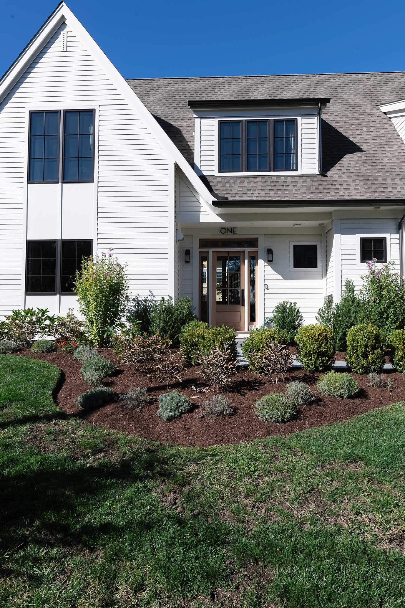Angled view of a custom home in the Hill and Harbor district, featuring architectural details that honor the area