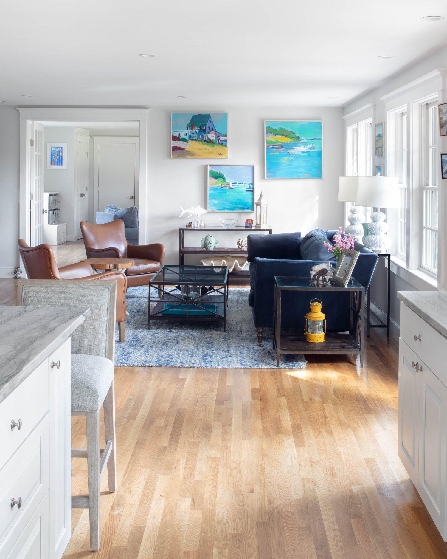 Cozy, light-filled living room created by enclosing an existing porch, part of a strategic first-level home addition.