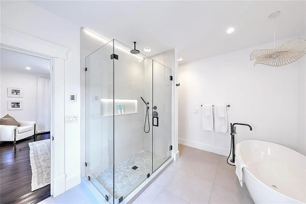 Modern master bathroom renovation featuring a large glass-enclosed shower and soaking tub, part of a reconfigured second-floor layout.