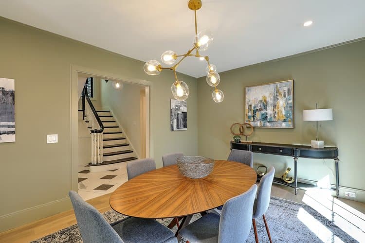 Contemporary dining room design with olive green walls, bridging the gap between historic architecture and modern style.