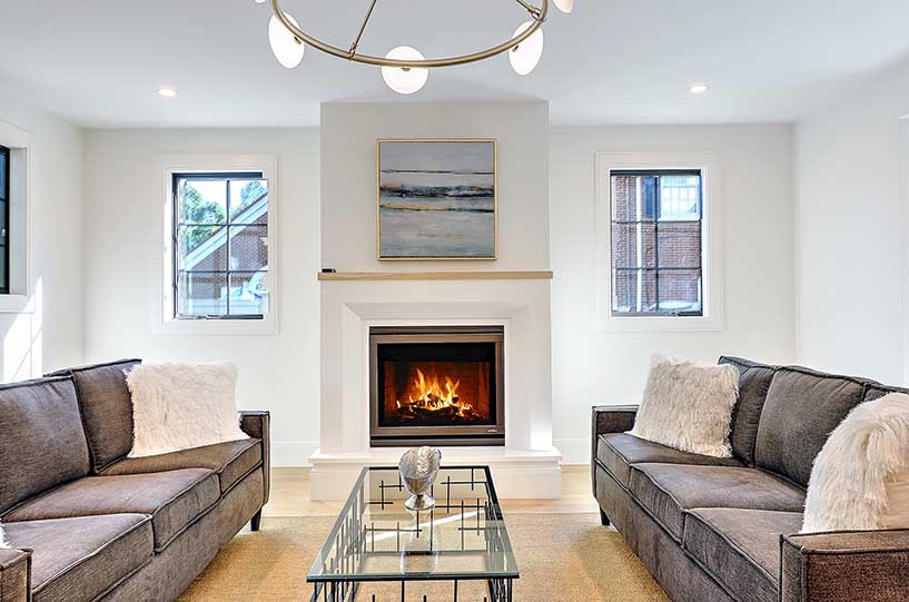 Contemporary living room featuring a sleek fireplace and neutral furnishings, wrapped in a historic shell.