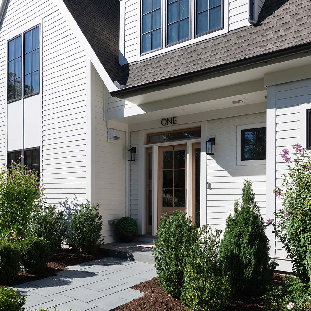 Exterior view of a finished modern custom home, illustrating the high-quality results of our end-to-end design, permitting, and construction management services.