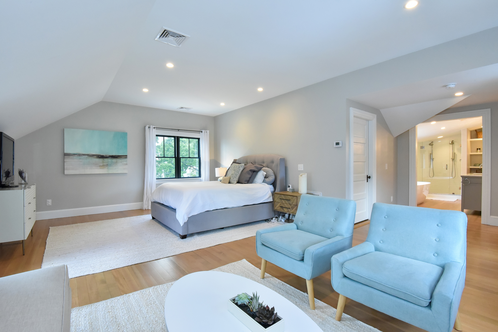 Bright and airy master bedroom design, part of a second-story addition that seamlessly blends with the original home.