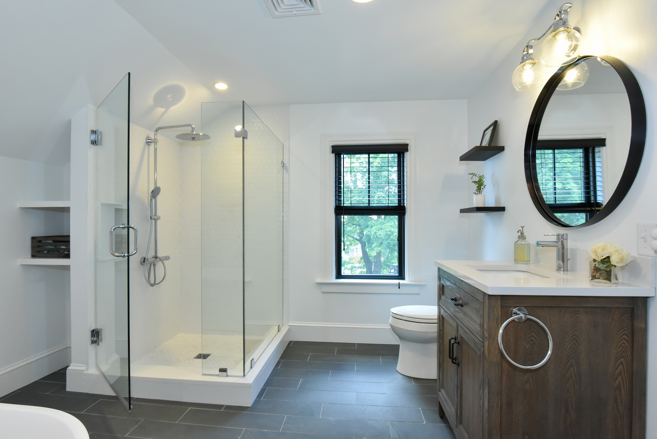 Modern bathroom renovation featuring a glass-enclosed shower and dark wood vanity.