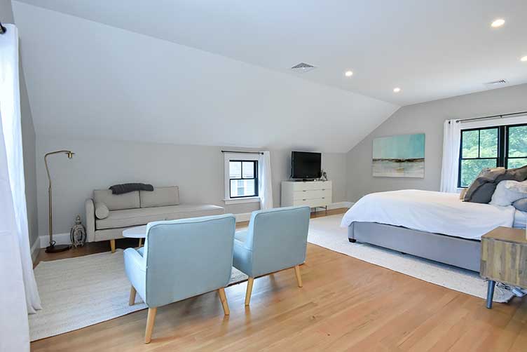 Spacious primary suite addition featuring vaulted ceilings and a comfortable seating area.